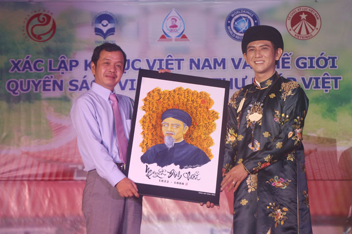 Nghệ nhân Vũ Đăng học trao quyển sách tượng trưng cho đại diện Thư viện Nguyễn Đình Chiểu
